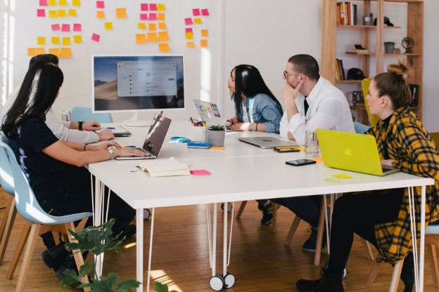 group of people sat at a table looking at a screen